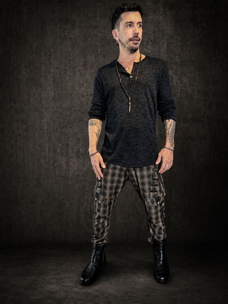 Man wearing The Circus Pants, handmade plaid wool cargo pants with tapered fit, utility pockets, and festival styling.